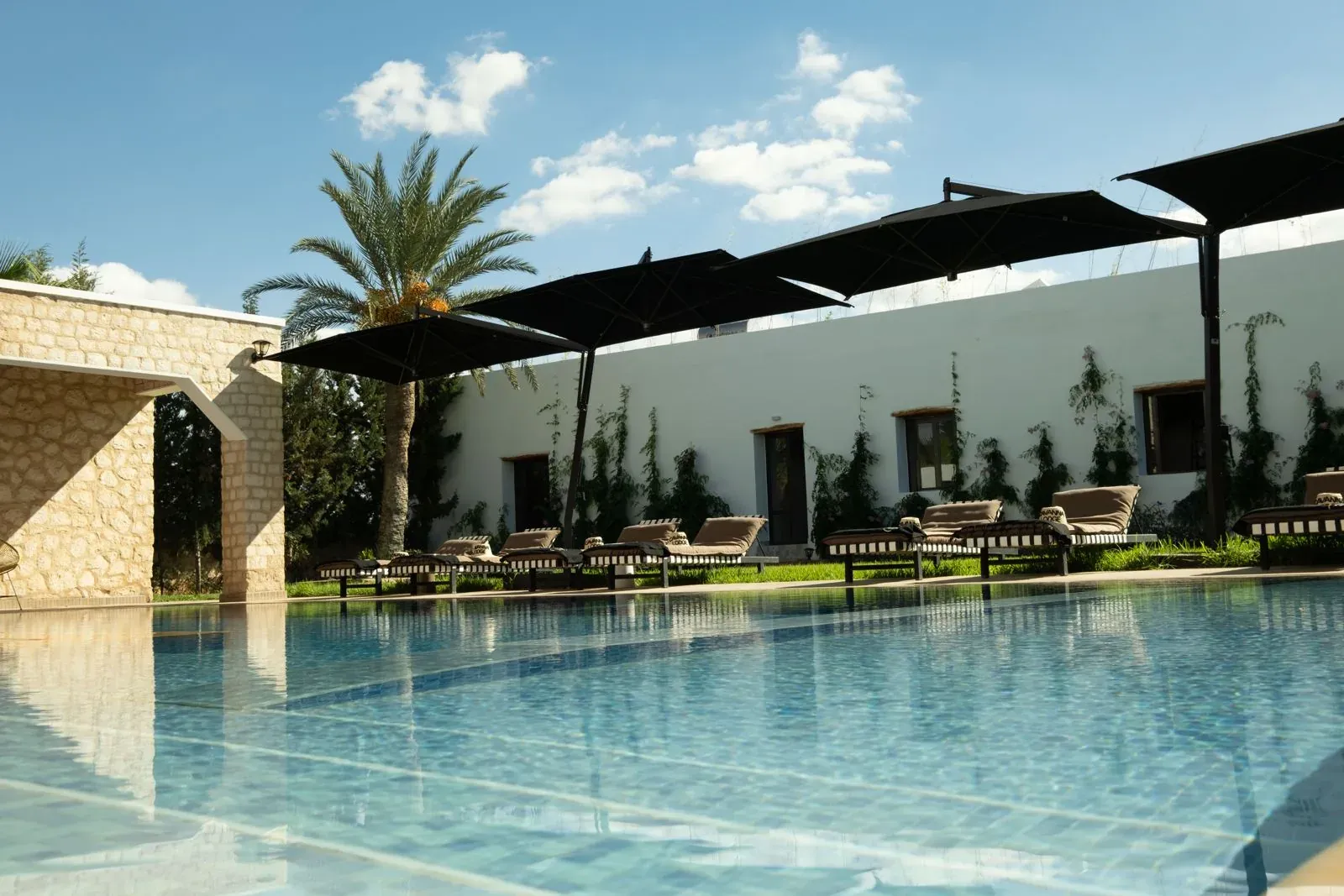 La piscine vue de l’arche en pierre